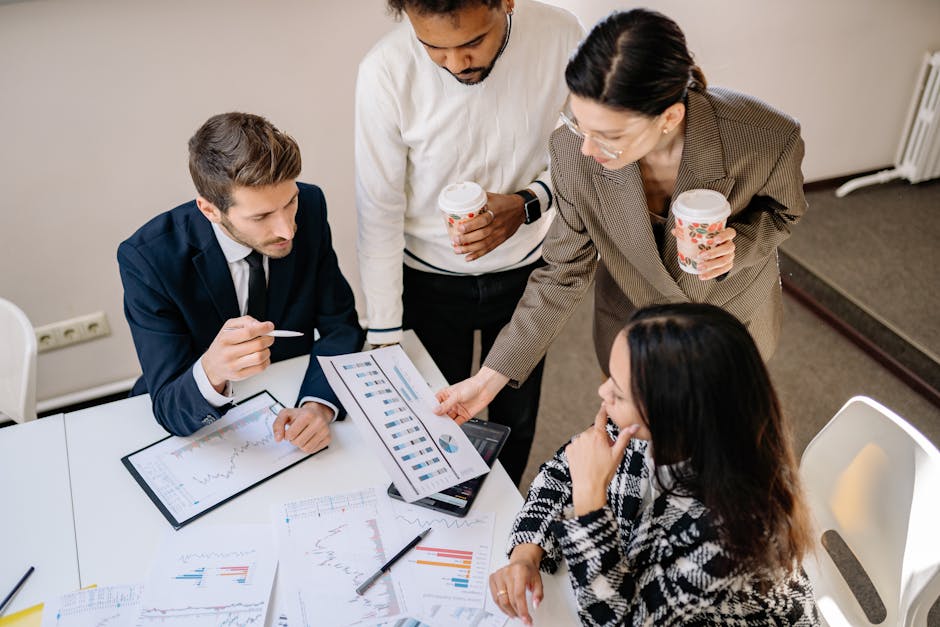 Four colleagues discuss data and strategy in an office setting.